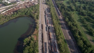 AX0001_006 - 4.8K aerial stock footage flying over Burnham Woods Golf Course, revealing a train yard and Powder Horn Lake, Illinois