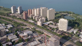 AX0001_011 - 4.8K aerial stock footage tilt from train tracks, revealing Hyde Park apartment buildings, Chicago, Illinois