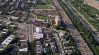 AX0001_013 - 4.8K aerial stock footage tilt from homes by the train tracks to reveal the Downtown Chicago skyline, Illinois