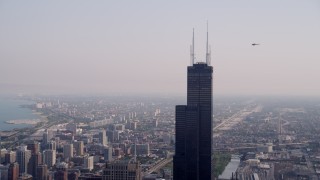 AX0001_043 - 4.8K aerial stock footage orbiting the top of the Willis Tower on a hazy day, Chicago, Illinois