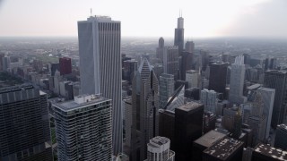 AX0001_050 - 4.8K aerial stock footage orbiting Aon Center and Two Prudential Plaza, on a hazy day, Downtown Chicago, Illinois