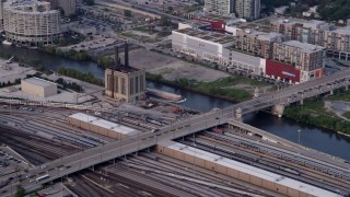 AX0001_073 - 4.8K aerial stock footage of reverse view of a barge chugging down the Chicago River, Illinois, seen from a riverfront train yard