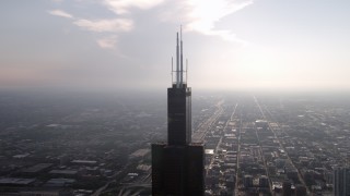 AX0001_083 - 4.8K aerial stock footage of the top of the Willis Tower on a hazy day, Downtown Chicago, Illinois