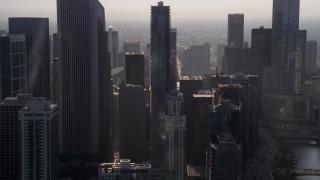 AX0001_094 - 4.8K aerial stock footage flying by downtown Chicago skyscrapers, revealing Jay Pritzker Pavilion, on a hazy day, Illinois