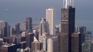 AX0001_112 - 4.8K aerial stock footage of a helicopter hovering near Willis Tower Skydeck in Downtown Chicago, on a hazy day, Illinois