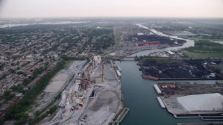 AX0001_168 - 4.8K aerial stock footage following Calumet River toward bridge between lime plant and petroleum coke, East Side Chicago, Illinois