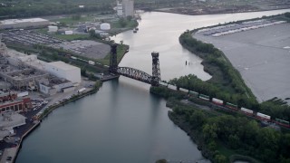 AX0001_171 - 4.8K stock footage aerial video tracking a train crossing a bridge spanning the Calumet River in Hegewisch, Chicago, Illinois