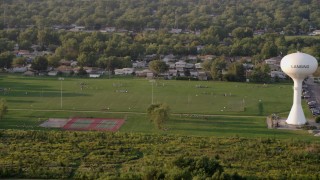AX0001_178 - 4.8K stock footage aerial video players playing football at Thornton Fractional South High School in Lansing, on a hazy day, Illinois
