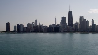AX0002_020 - 4.8K aerial stock footage of flying low over Lake Michigan, tilt up to reveal Downtown Chicago, Illinois