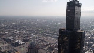 AX0002_031 - 4.8K aerial stock footage of flying by Willis Tower toward West Chicago, on a hazy day, Illinois