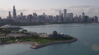 AX0002_086 - 4.8K stock footage aerial video of orbiting the Adler Planetarium with the Downtown Chicago skyline and harbor in background, Illinois