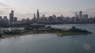 AX0002_088 - 4.8K aerial stock footage of the Downtown Chicago skyline seen while flying by Adler Planetarium, Illinois
