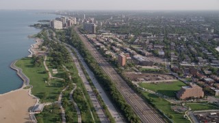 AX0002_092 - 4.8K aerial stock footage follow Highway 41 and train tracks toward Hyde Park waterfront apartment buildings, Chicago, Illinois