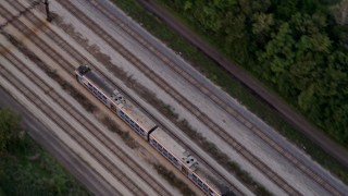AX0003_024 - 4.8K aerial stock footage of a bird's eye view of a commuter train traveling through Kenwood at twilight, Chicago, Illinois