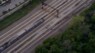 AX0003_025 - 4.8K aerial stock footage of a bird's eye of a commuter train speeding through Kenwood at twilight, Chicago, Illinois