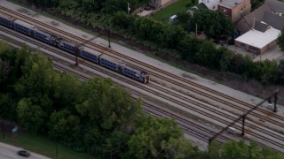 AX0003_026 - 4.8K aerial stock footage of a commuter train passing through Kenwood, Chicago, Illinois, twilight