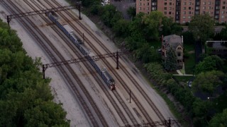 AX0003_027 - 4.8K aerial stock footage track commuter train traveling through Kenwood at twilight, Chicago, Illinois