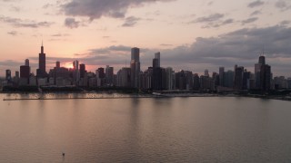 AX0003_031 - 4.8K aerial stock footage of flying by the skyline from over Lake Michigan, Downtown Chicago, Illinois, sunset