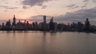 AX0003_032 - 4.8K aerial stock footage of the Downtown Chicago skyline seen from Lake Michigan, on a cloudy day at sunset, Illinois