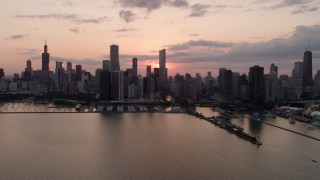 AX0003_033 - 4.8K aerial stock footage of the Downtown Chicago skyline, reveal Navy Pier, cloudy sunset, Illinois