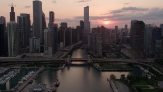 AX0003_034 - 4.8K stock footage aerial video tilt from the lake to reveal Downtown Chicago at sunset with clouds, Illinois