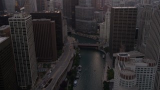 AX0003_037 - 4.8K aerial stock footage of following the river toward base of Trump Tower at sunset, Downtown Chicago, Illinois