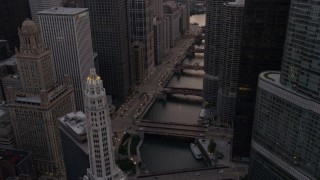 AX0003_038 - 4.8K aerial stock footage of following the river between Mather Tower and Trump Tower at sunset, Downtown Chicago, Illinois