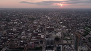 AX0003_042 - 4.8K aerial stock footage follow W Fulton Street over apartment buildings in West Chicago at sunset with clouds, Illinois
