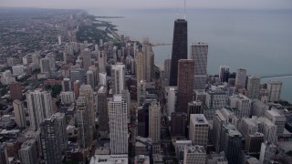 AX0003_050 - 4.8K aerial stock footage of flying over Downtown Chicago, approach John Hancock Center on a cloudy day at sunset, Illinois
