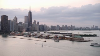AX0003_064 - 4.8K aerial stock footage orbit Navy Pier, revealing Downtown Chicago skyline, on a cloudy day at sunset, Illinois