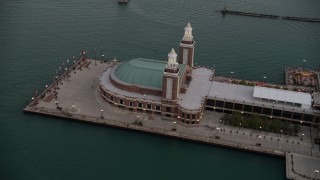 AX0003_067 - 4.8K aerial stock footage of flying by the end of Navy Pier on a cloudy day at sunset, Chicago, Illinois