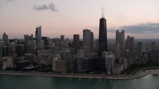 AX0003_070 - 4.8K aerial stock footage of John Hancock Center and lakefront skyscrapers, seen from Lake Michigan, with clouds at twilight, Illinois