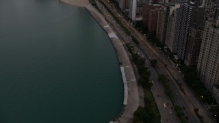 AX0003_074 - 4.8K aerial stock footage tilt from Lake Shore Drive, revealing Downtown Chicago buildings, on a cloudy day at sunset, Illinois