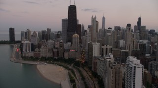 AX0003_075 - 4.8K aerial stock footage of following Lake Shore Drive to approach the Drake Hotel, John Hancock Center at sunset, Downtown Chicago, Illinois