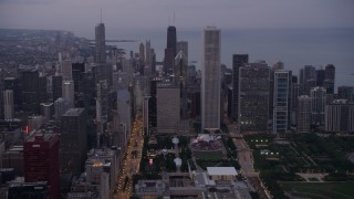 AX0003_083 - 4.8K aerial stock footage tilt from Buckingham Fountain at Grant Park, revealing Downtown Chicago skyscrapers, on a hazy day at sunset, Illinois