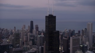 AX0003_085 - 4.8K aerial stock footage of an orbit of the top of Willis Tower on a cloudy day at sunset, Chicago, Illinois