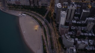 AX0003_096 - 4.8K aerial stock footage tilt from Lake Shore Drive and up N Michigan Avenue, reveal the Drake Hotel and Downtown Chicago buildings, at twilight, Illinois