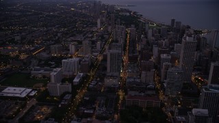 AX0003_111 - 4.8K aerial stock footage tilt from N Clark Street and follow it north through Downtown Chicago, Illinois, twilight