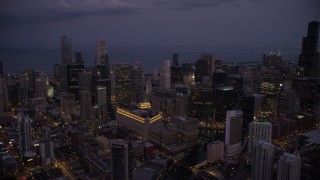 AX0003_114 - 4.8K aerial stock footage of a view across Downtown Chicago at sunset, with Lake Michigan in the background at twilight, Illinois