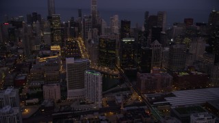 AX0003_115 - 4.8K aerial stock footage tilt from train station to Chicago River and skyscrapers, Downtown Chicago, Illinois, twilight
