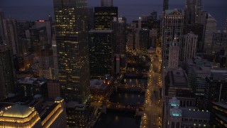 AX0003_117 - 4.8K aerial stock footage of following the Chicago River through downtown at twilight, Downtown Chicago, Illinois