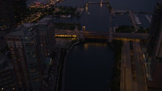 AX0003_121 - 4.8K stock footage aerial video of following Chicago River over a bridge at the mouth of the river, revealing Navy Pier, Downtown Illinois, twilight