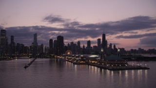 AX0003_124 - 4.8K aerial stock footage orbit the end of Navy Pier at twilight, and reveal the skyline of Downtown Chicago, Illinois