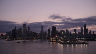 AX0003_125 - 4.8K aerial stock footage of passing by the end of Navy Pier with a view of the Downtown Chicago skyline at twilight, Illinois