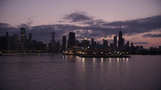 AX0003_128 - 4.8K aerial stock footage of flying by Navy Pier with the Downtown Chicago skyline in the background at twilight, Illinois