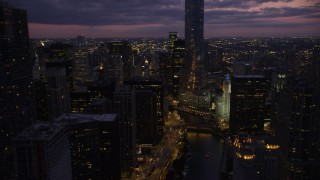 AX0003_133 - 4.8K aerial stock footage of following the Chicago River toward the base of Trump Tower Chicago at twilight, Illinois
