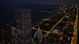 AX0003_145 - 4.8K aerial stock footage of flying by Two Prudential Plaza and Aon Center to approach Grant Park at night, Downtown Chicago, Illinois