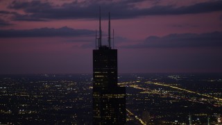 AX0003_149 - 4.8K aerial stock footage of orbiting the top of Willis Tower, on a cloudy day at night, Downtown Chicago, Illinois