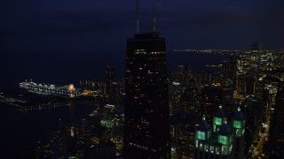 AX0003_158 - 4.8K aerial stock footage orbit John Hancock Center, reveal Navy Pier, Downtown Chicago, Illinois, night