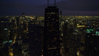 AX0003_159 - 4.8K aerial stock footage orbiting John Hancock Center and Downtown Chicago skyscrapers, at night, Illinois